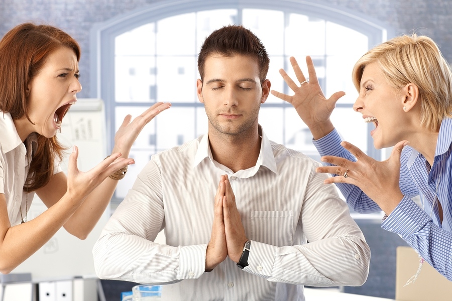 Meditating closed eye businessman in office with arguing colleagues shouting and fighting.
